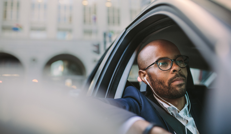 man listening to podcast in his car